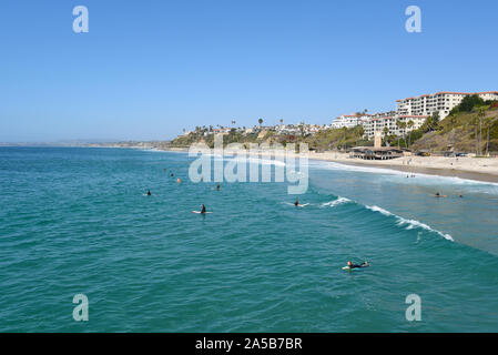 SAN CLEMENTE, CALIFORNIA - 18 OTT 2019: la spiaggia e la fascia costiera con surfers e lucertole da mare visto dal molo nel South Orange County spiaggia cittadina. Foto Stock