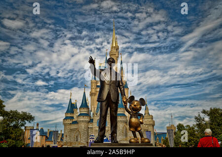 Castello di Cenerentola nel Magic kingdom con Walt Disney e Mickey statua in primo piano e le nuvole in cielo sullo sfondo, Orlando, Florida Foto Stock