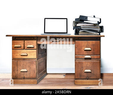 Laptop e cartella giacente su un vintage scrivania in una stanza con pavimento in legno Foto Stock