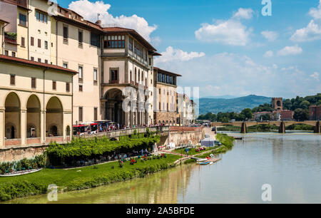Vista degli antichi edifici medievali sulla riva meridionale dell'Arno, a Firenze, in Italia, con il Ponte della Trinità sullo sfondo. Foto Stock