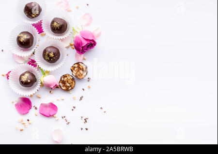 Modello di dolce. Vista superiore artigianale di cioccolatini con noci e miele. Deliziosi cioccolatini su uno sfondo bianco. Close-up. Soft focus. Spazio di copia Foto Stock