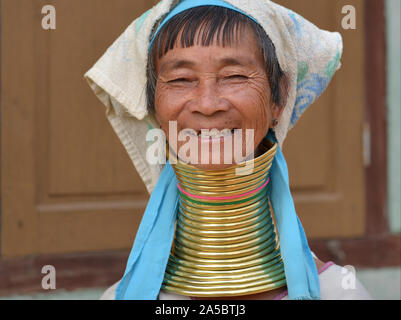 Anziani Myanmarese Kayan Lahwi giraffa donna ("donna giraffa") con 22 ottone tribale collo anelli/bobine sorrisi per la fotocamera. Foto Stock