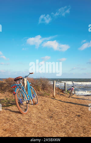 Bici da l'ingresso alla spiaggia sulla isola di Hiddensee, Mar Baltico, Germania settentrionale. Luminosa giornata di vento con cielo blu e nuvole in autunno o in inverno se Foto Stock