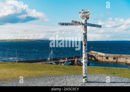 Il famoso John O'semole signpost pole, intonacate con adesivi da turisti, all'estremo nord punta orientale del Regno Unito Foto Stock