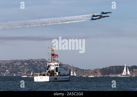 Blue Angels F-18 calabroni nella formazione di diamante passano sopra i Guardacoste Luccio (WPB-87365) durante un 2019 di San Francisco la settimana della flotta demonstr volo Foto Stock