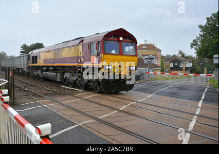 DB Cargo Classe 66 66172 locomotiva passa il passaggio a livello marzo congiunzione Sud sulla linea Ely-Peterborough, Cambridgeshire, Regno Unito Foto Stock