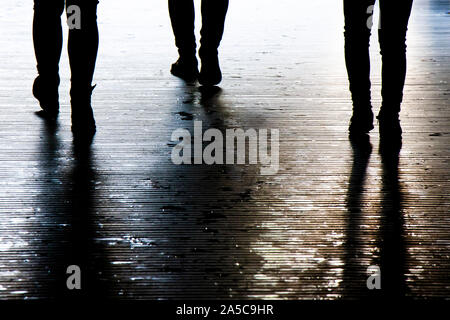 Sfocata ombra silhouette di un popolo a piedi di notte, dettaglio delle gambe Foto Stock