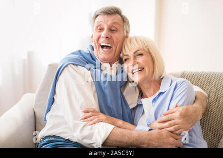 Coppia senior ridere insieme, in un momento di relax a casa Foto Stock