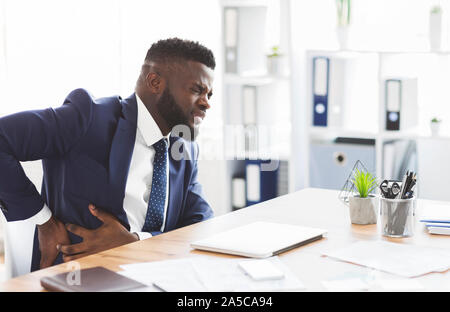 Imprenditore tenendo il suo lato, che soffrono di dolore di fegato Foto Stock