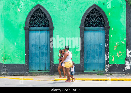 Igarassu, Brasile - Circa Agosto 2019: Famiglia passando davanti ad un edificio coloniale nel cuore del centro storico di Igarassu Foto Stock