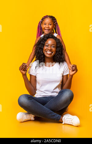Bella la mamma seduta sul pavimento e tenendo le mani con la figlia Foto Stock