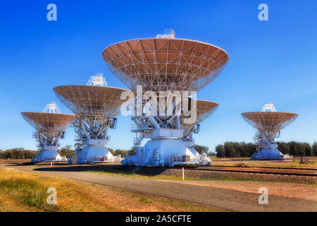 Piattaforme ferroviarie e le antenne di telefonia mobile piatti come parte della schiera di radio telescopi per osservare a distanza di oggetti astronomici in Coonabarabran Namoi Street di Australia Foto Stock