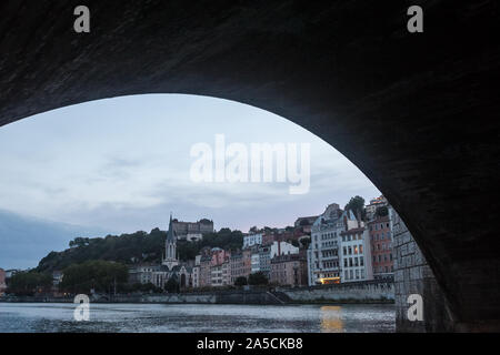 Panorama del fiume Saone e il Quai de Saone riverbank e il fiume nel centro della città di Lione, visto dall'arco di un antico ponte di pietra foto Foto Stock