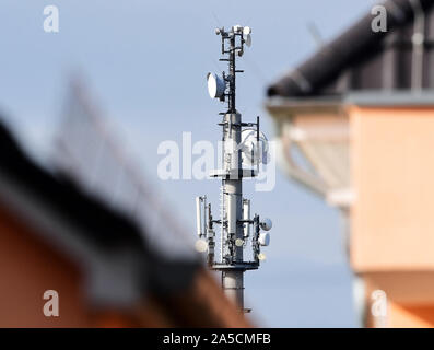 Bernau bei Berlin, Germania. Xvii oct, 2019. La prima trasmissione di Brandeburgo torre per il mobile standard radio 5G può essere visto dietro gli edifici residenziali. Il primo Brandenburger torre di trasmissione per la radio mobile standard 5G per telefonia e Internet sta al bordo della Oranienburger Straße. Vodafone mettere il trasmettitore nel funzionamento come parte di una dimensione nazionale 5G prova di funzionamento con montanti 80. Credito: Soeren Stache/dpa-Zentralbild/ZB/dpa/Alamy Live News Foto Stock