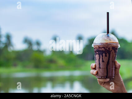 Raffreddamento di cioccolato a portata di mano le donne e vista sul fiume. Foto Stock