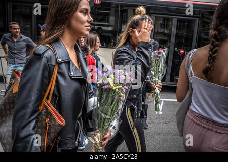 Barcellona, Spagna. Xix oct, 2019. Due giovani donne portano mazzi di fiori per rendere omaggio alle forze di polizia nazionali.Mattina di conferenze stampa dei partiti politici che rappresentano il sindacalismo spagnolo in Catalogna e spontaneo omaggi per il supporto di ieri le azioni della polizia di fronte alla stazione centrale di polizia di Vía Laietana. Credito: SOPA Immagini limitata/Alamy Live News Foto Stock