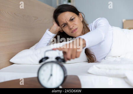 Angry Young razza mista donna irritato da un forte segnale di clock. Foto Stock