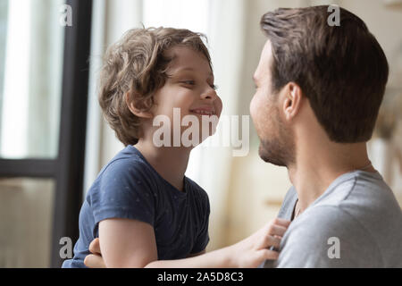 Carino piccolo figlio guardando al padre, godendo di momento di gara Foto Stock