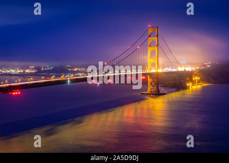 Vista dalla pastella Spencer al Golden Gate bridge con calda luce riflettendo alla superficie dell'acqua di San Francisco all'alba. Foto Stock