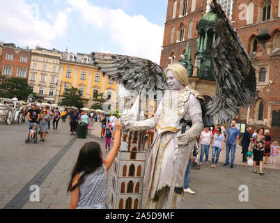 Cracovia. Cracovia. La Polonia. Street performer (Angel) al mercato principale posto nella parte anteriore della chiesa di S. Maria. Foto Stock