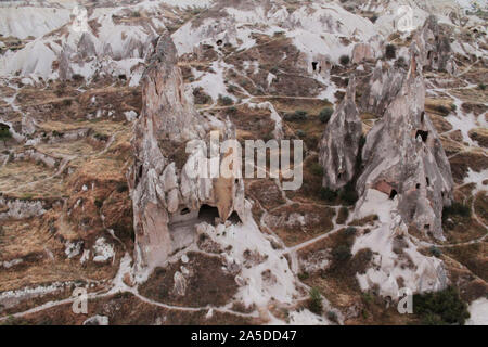 Cave Houses in coni colline di sabbia, circondato da sentieri. Fotografia di paesaggi di una popolare destinazione turistica - Cappadocia, Turchia Foto Stock