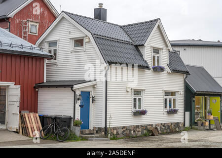 Circolo polare artico fjord cityscape di villaggio pittoresco con legno tradizionale casa bianca, girato sotto la luminosa luce torbida a Haenningsvaer, Lofoten, n. Foto Stock