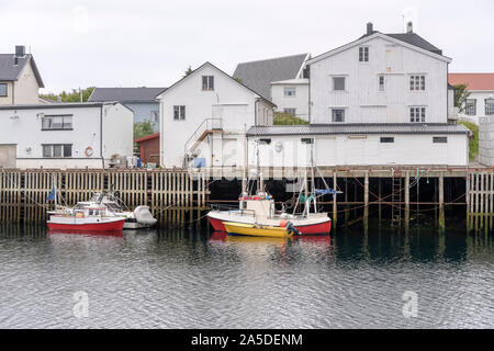 HENNINGSVAER, Norvegia - 13 Luglio 2019: Circolo Polare Artico fjord cityscape del pittoresco villaggio mostra tradizionali di palafitte sul terrapieno e pesca bo Foto Stock