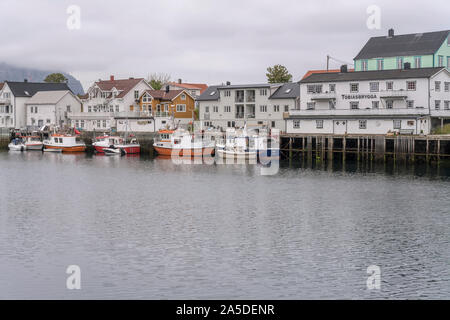 HENNINGSVAER, Norvegia - 13 Luglio 2019: Circolo Polare Artico fjord cityscape del pittoresco villaggio mostra di barche da pesca e le tradizionali palafitte sul embankm Foto Stock