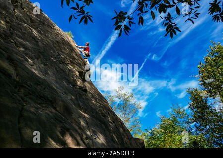 Rocciatore in rosso alla roccia di granito di Auzat, la regione Ariège, Pirenei, della Francia meridionale, Foto Stock