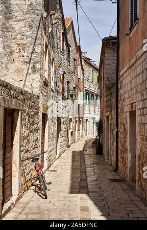 In bicicletta in una stretta viuzza a Stari Grad Hvar, Dalmazia, Croazia, Europa Foto Stock