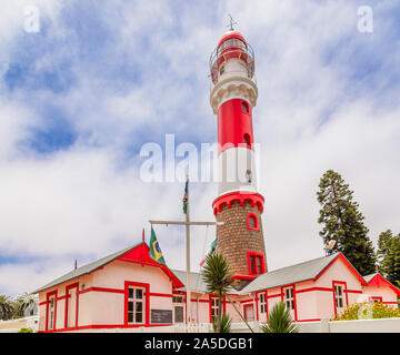 Rosso dipinto di bianco del faro rotante e case, Swakopmund, Tedesco città coloniale, Namibia Foto Stock