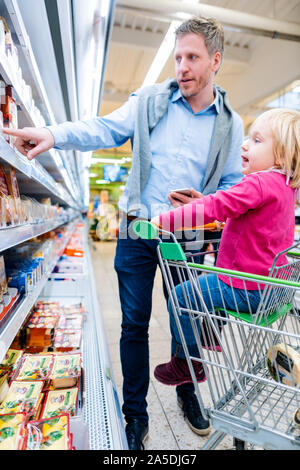 L'uomo con il suo bambino nel reparto freschi del supermercato Foto Stock