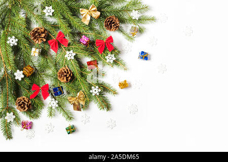 Albero di Natale decorato di diramazione con coni, i fiocchi di neve e archi su sfondo bianco Foto Stock