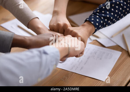 Diverse persone mettere i pugni in cerchio come simbolo di unità Foto Stock