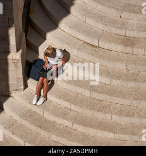 Overhead di ragazza su gradini con computer portatile nella città vecchia di Dubrovnik Croazia Foto Stock