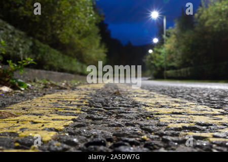 Un basso vista prospettica tra il giallo della segnaletica stradale Foto Stock