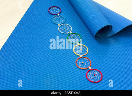 Blue materassino yoga e sette chakra decorazione. Concetto di yoga. Foto Stock