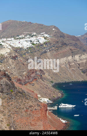 Vista della parte orientale del villaggio di Oia a Santorini, Grecia con il piccolo porto. Foto Stock