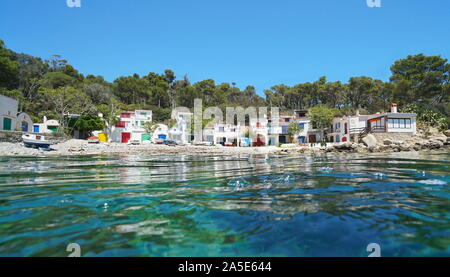 In Spagna, in Catalogna, costa mediterranea con tranquillo case di pescatori sulla spiaggia rocciosa visto dalla superficie del mare, Costa Brava, Cala S'Alguer, Palamos Foto Stock