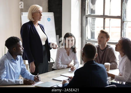 Di mezza età femmina professionale mentor leader executive briefing aziendale Foto Stock