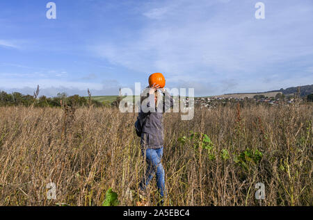 Worthing Regno Unito xx ottobre 2019 - Una donna porta la sua zucca sul suo capo a scegliere il proprio centro di zucca al Sompting vicino a Worthing in West Sussex su una graziosa soleggiata giornata autunnale . Credito : Simon Dack / Alamy Live News Foto Stock