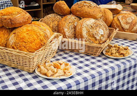 Le pagnotte di pane visualizzati in cesti in blu e bianco tovaglia controllati Foto Stock