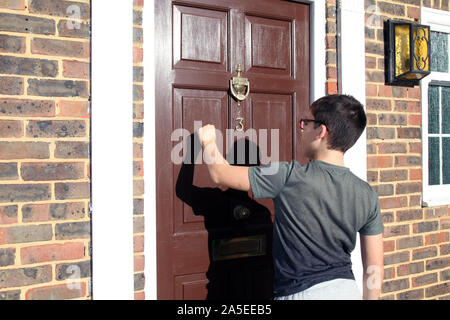 Bambino a bussare alla porta anteriore, numero 3, indossando occhiali, marrone porta, Georgian House, REGNO UNITO Foto Stock