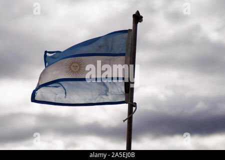 Bandiera argentina sventolando in un giorno nuvoloso in Patagonia, Argentina Foto Stock