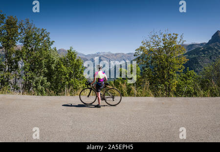 Femmina matura ciclista tenendo in vista, Oisans, sulle alpi francesi. Foto Stock