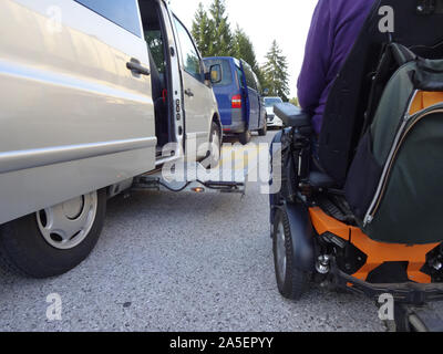 Gli uomini disabili su sedia a rotelle con veicolo accessibile con ascensore Foto Stock