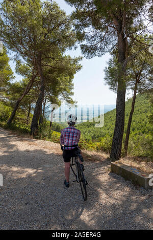 Femmina matura ciclista tenendo nella vista, Provenza, Francia. Foto Stock