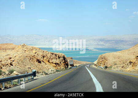 Deadseaview su una curva strada di sabbia su una autostrada che corre lungo il Mar Morto da un lato e Edom montagne di Arava deserto da altri in Israele. Foto Stock