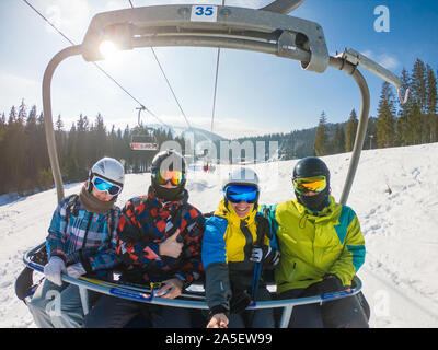 Gli amici di ski lift tenendo selfie Foto Stock