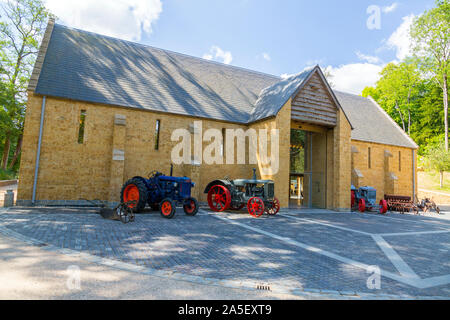 Vintage trattori e macchinari agricoli al di fuori del granaio di trebbiatura presso il recentemente restaurato "Il Tritone in Somerset' giardino e hotel, nr Bruton, England, Regno Unito